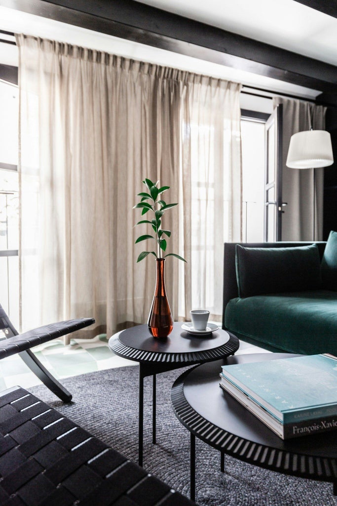 Elegant junior suite with modern Scandinavian design, soft neutral tones, plush white bedding, and sleek minimalist furnishings in Barcelona hotel room