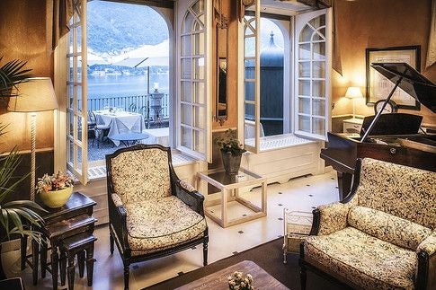 Elegant lakeside villa with terracotta rooftops, lush gardens, and Lake Como panorama, showcasing luxurious Italian architectural charm and scenic tranquility