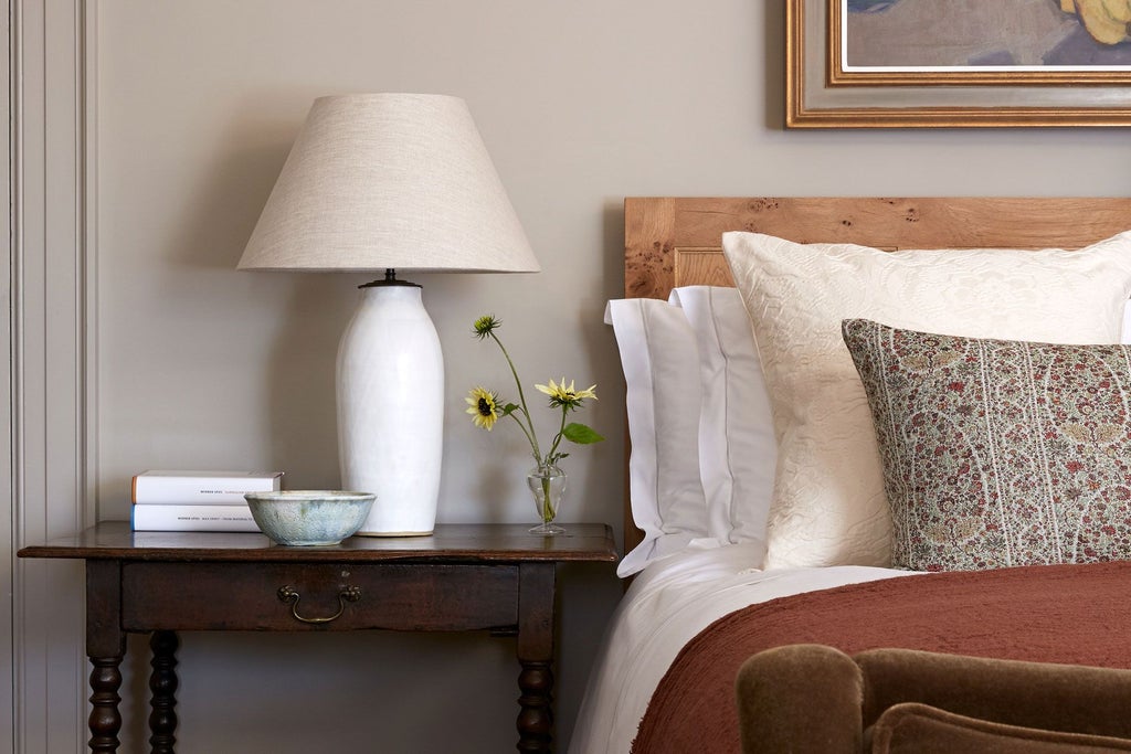 Elegant chamber room with soft neutral tones, plush bedding, antique wooden furniture, and soft natural light illuminating refined British countryside hotel interior