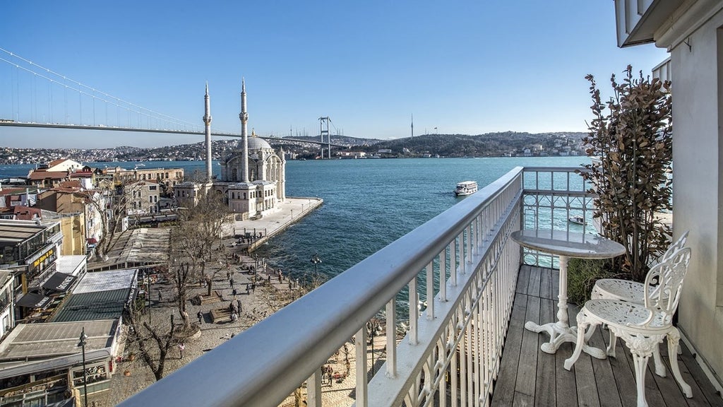 Luxurious penthouse suite overlooking Bosphorus, featuring elegant modern decor, floor-to-ceiling windows, and panoramic Istanbul skyline view at sunset