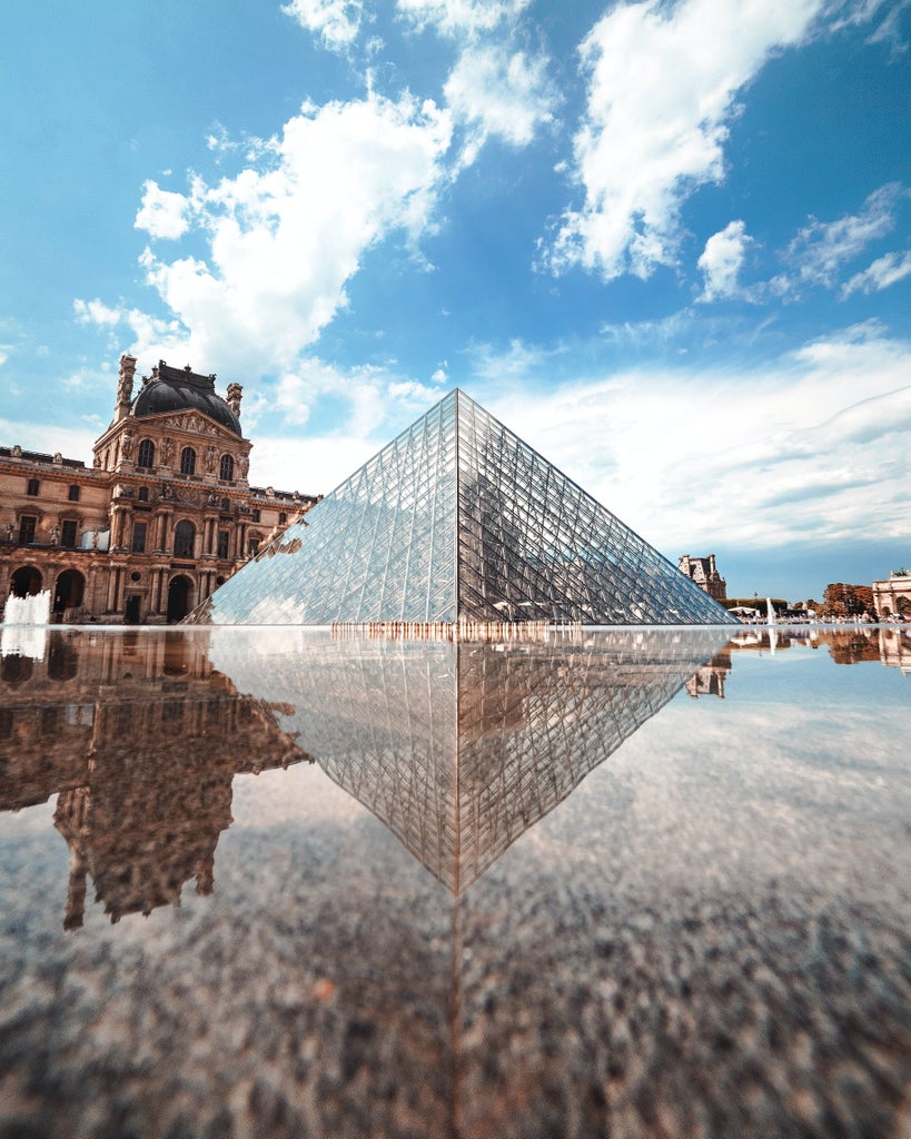 Elegant visitors explore grand halls of the Louvre Museum, iconic glass pyramid gleaming, masterpieces of art surrounding luxurious marble corridors in Paris