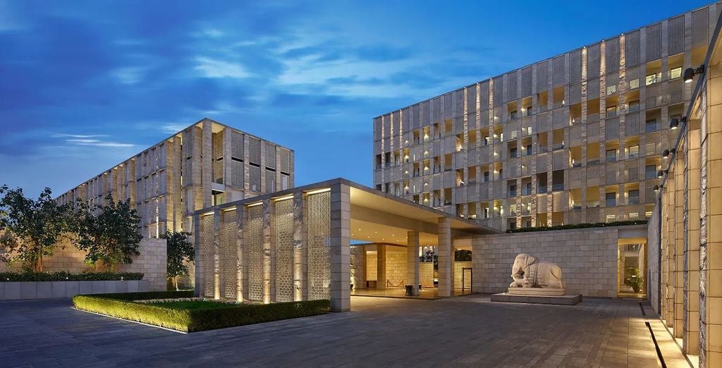 Luxurious facade of The Lodhi hotel in India featuring modern architecture, reflecting pools, and manicured gardens at twilight