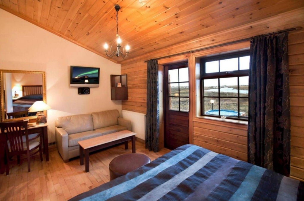 Snow-covered luxury lodge Hotel Rangá with wooden exterior and warm glowing windows nestled under a starlit Icelandic winter sky