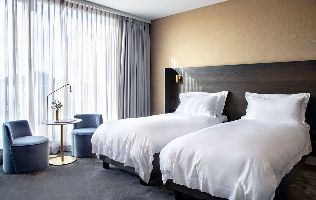 Elegant twin beds with crisp white linens in a luxurious hotel room at Pillows Grand Boutique Hotel Reylof, featuring sophisticated Belgian design