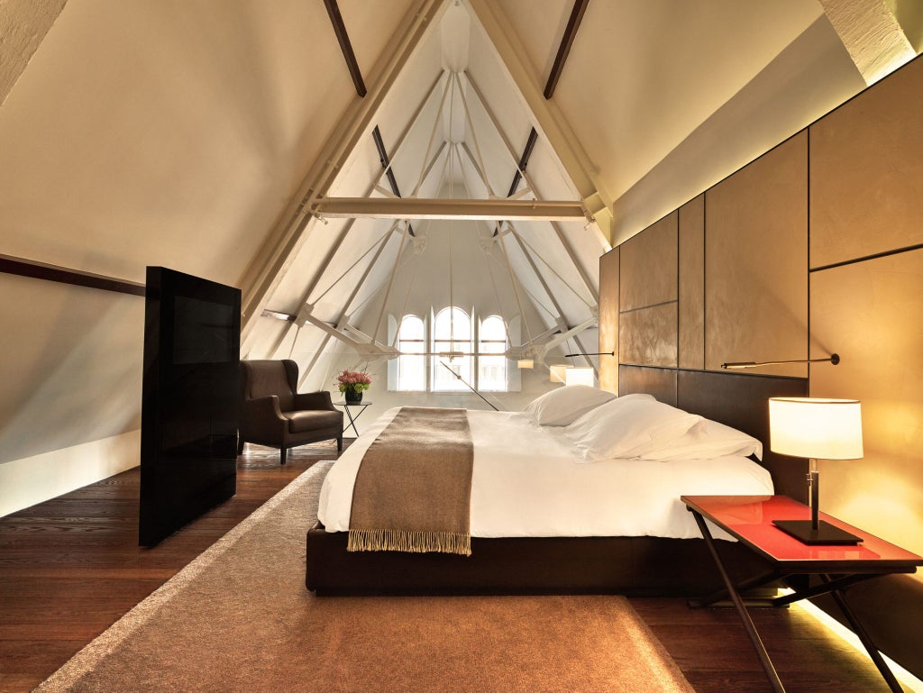 Elegant two-bedroom suite with modern Dutch design, featuring plush furnishings, expansive windows, and soft neutral tones in Scenset's Conservatorium Hotel.