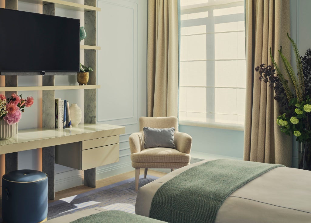 Luxurious deluxe hotel room at One Aldwych with elegant contemporary design, plush bedding, and sophisticated neutral color palette showcasing urban sophistication