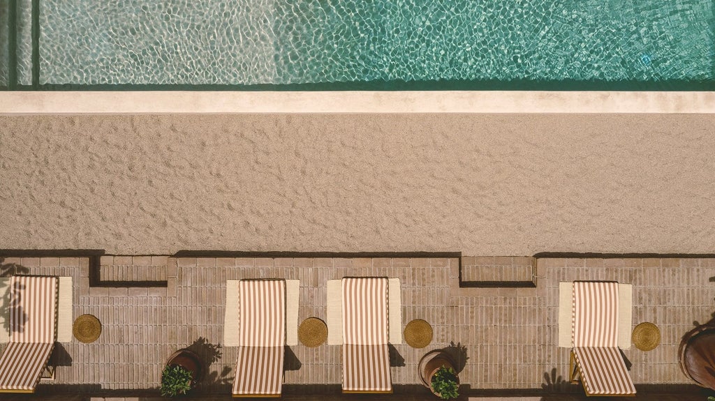 Luxurious beachfront hotel with white stucco walls, palm trees, and azure pool overlooking the scenic coastline of coastal Mexico