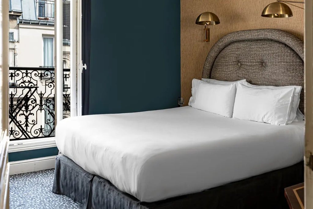 Luxurious Parisian hotel room with elegant decor, plush king bed, vintage-inspired furnishings, and warm ambient lighting in the Grand Pigalle Hotel, France