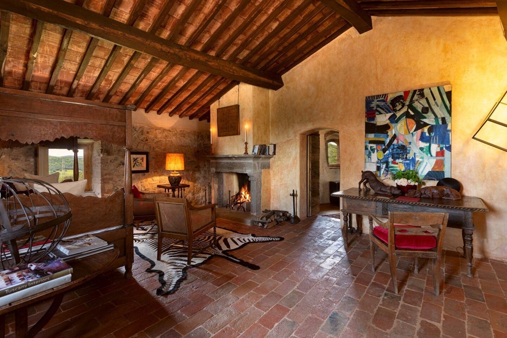 Elegant Tuscan suite with rustic stone walls, antique wood furnishings, plush white bedding, and panoramic countryside views at Castello di Vicarello