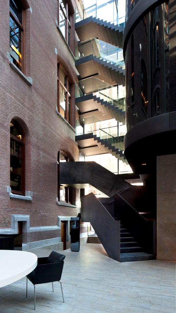 Luxurious glass and steel facade of Scenset Conservatorium Hotel in Amsterdam, blending modern architecture with historic museum building elegance