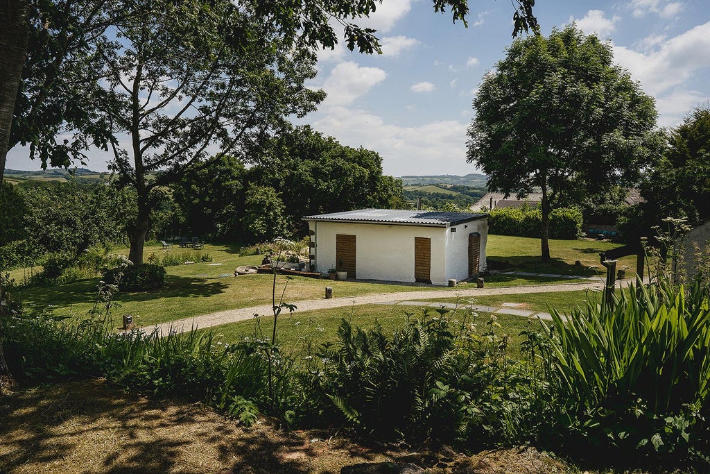 Elegant stone farmhouse hotel nestled in lush UK countryside, featuring rustic architecture, verdant gardens, and timeless countryside charm at scenset Barton