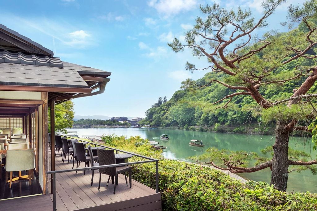 Traditional Japanese ryokan with wooden exterior nestled among autumn trees, featuring a serene garden and elegant sliding doors