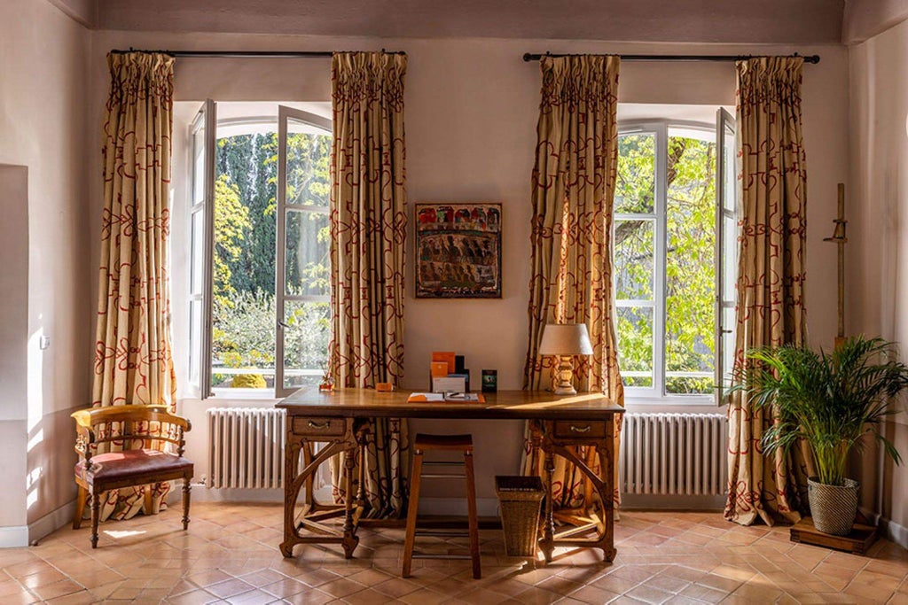 Elegant French countryside hotel room with soft cream walls, antique wooden furniture, and refined Provençal decor near historic abbey