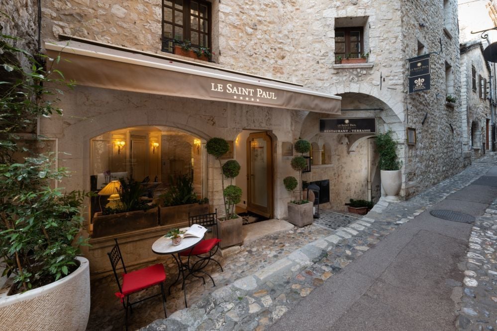 Elegant stone facade of Hotel Le Saint Paul, nestled in charming French village with traditional architecture and inviting warm-toned exterior