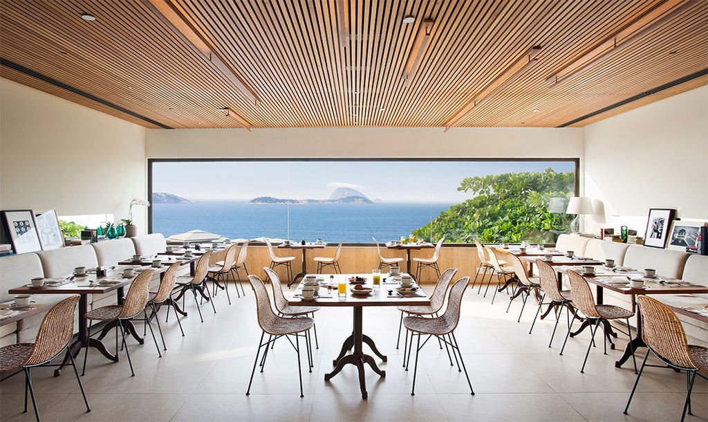 Luxurious Hotel Fasano Rio de Janeiro at sunset, featuring an infinity rooftop pool overlooking Ipanema Beach and mountains in Brazil