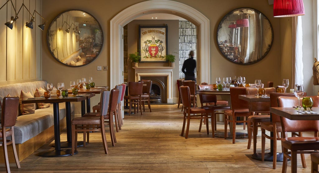 Elegant Victorian-era stone hotel exterior with arched windows, manicured gardens, and warm lighting showcasing British architectural grandeur in the countryside.