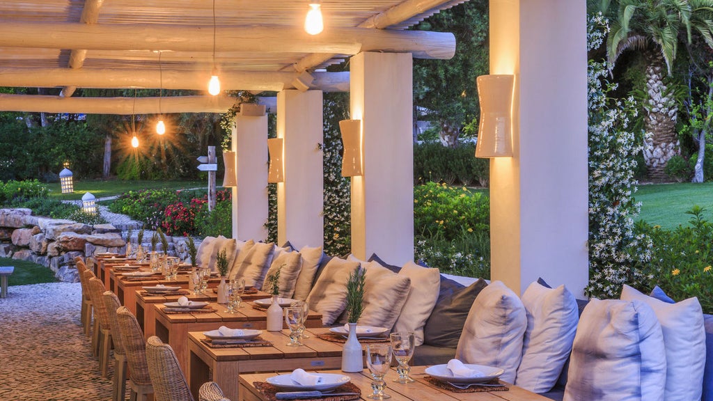 Elegant whitewashed boutique hotel in rural Portugal with terracotta roof tiles, surrounded by lush gardens and serene countryside