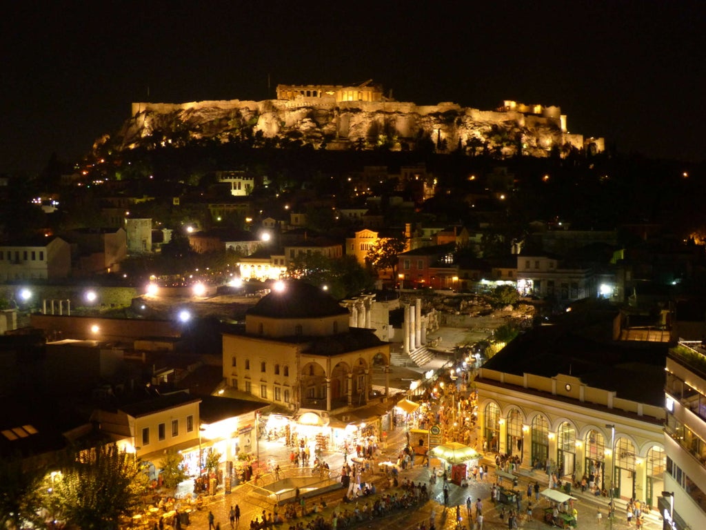 Elegant tablescape with local Greek wines, fresh Mediterranean ingredients, and Athenian sunset view showcasing gourmet culinary experience in scenic Greece