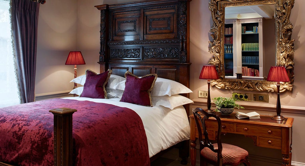 Elegant club double room with plush velvet headboard, antique furnishings, soft romantic lighting, and intricate Georgian-inspired decor at Batty Langley's boutique hotel