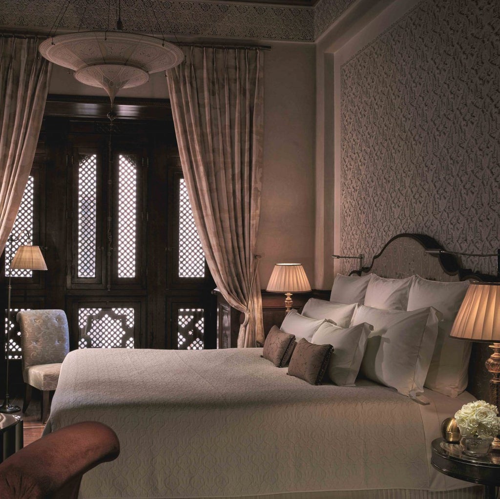 Elegant white and beige exterior of a luxury Moroccan hotel featuring traditional arched windows, ornate balconies and manicured gardens