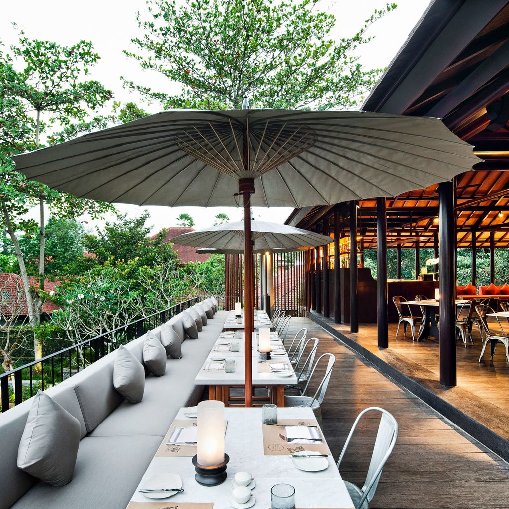 Elegant infinity pool overlooking lush Balinese jungle at COMO Uma Ubud, with stone decking and traditional thatched-roof pavilions