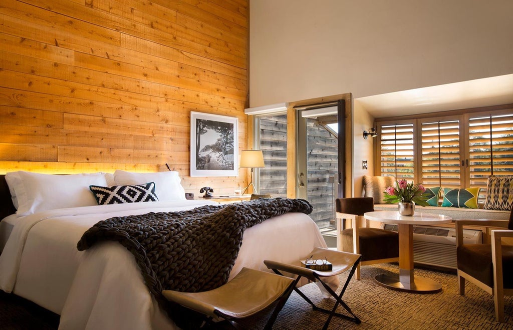 Luxurious guestroom with warm fireplace, rustic wooden furnishings, plush bedding, and elegant mountain resort ambiance at Ventana Big Sur in scenic California