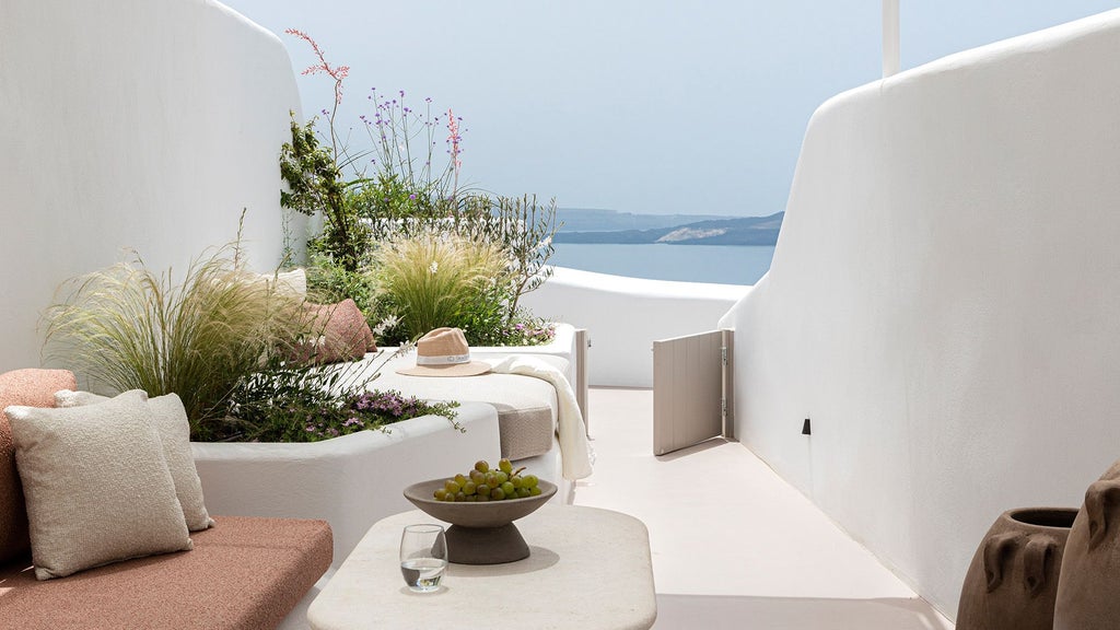 Luxurious white-washed Cycladic senior suite with private infinity pool overlooking azure Aegean Sea, minimalist design and elegant contemporary furnishings