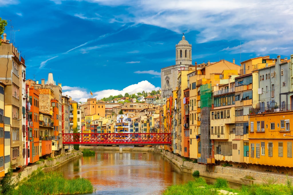 Historic stone archways and medieval cobblestone streets in Girona's Jewish Quarter showcase the city's architectural grandeur at sunset