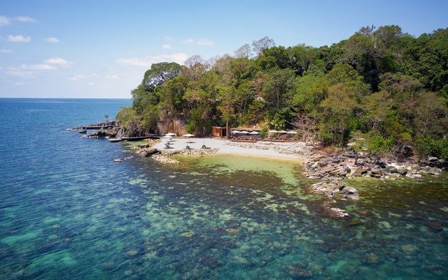 Luxurious overwater villa with infinity pool overlooking turquoise ocean, surrounded by tropical foliage at Six Senses Krabey Island resort