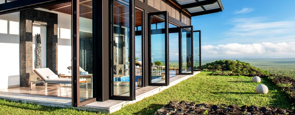 Luxurious eco-lodge perched on volcanic terrain in the Galapagos, with sleek modern architecture blending seamlessly into dramatic natural landscape