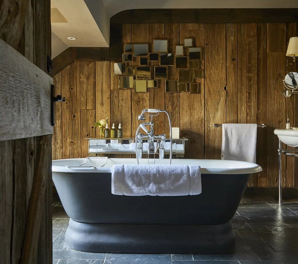 Luxurious wooden forest cabin room at Lime Wood hotel, featuring warm neutral tones, rustic timber walls, plush bedding, and elegant minimalist design