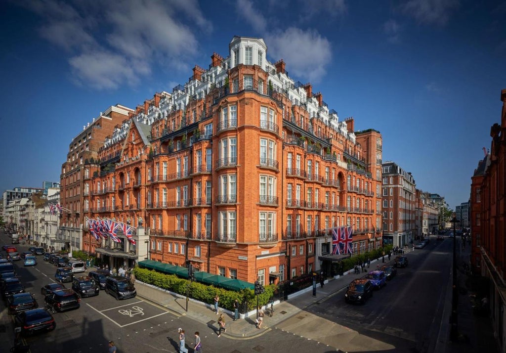 Iconic Art Deco facade of Claridge's Hotel in Mayfair, featuring ornate cream stonework, wrought-iron balconies, and elegant entrance awning