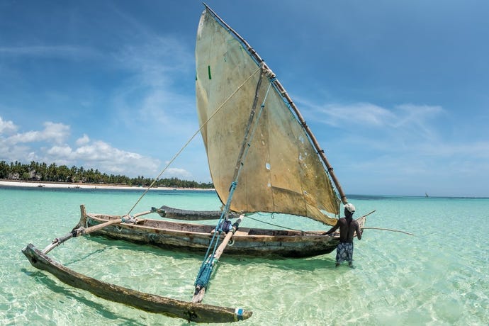 A local fisherman heading out in a traditional dhow boat