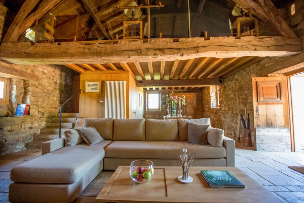 Elegant French countryside cottage with stone walls, rustic wooden furniture, and soft natural light illuminating a luxurious, tranquil bedroom interior