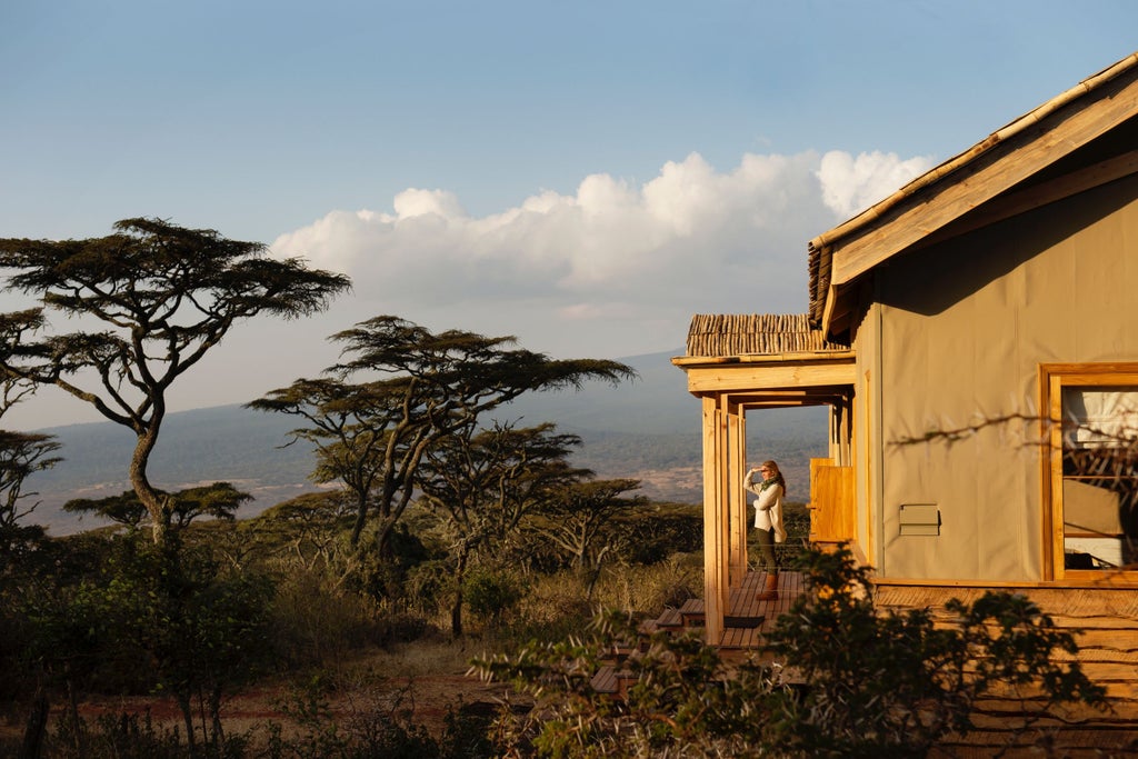 Luxurious safari tents perched on Ngorongoro Crater rim with canvas walls, wooden deck, and panoramic savanna views at sunset