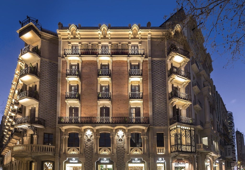 Elegant five-star Monument Hotel in Barcelona with ornate stone facade, wrought iron balconies and classical Mediterranean architecture