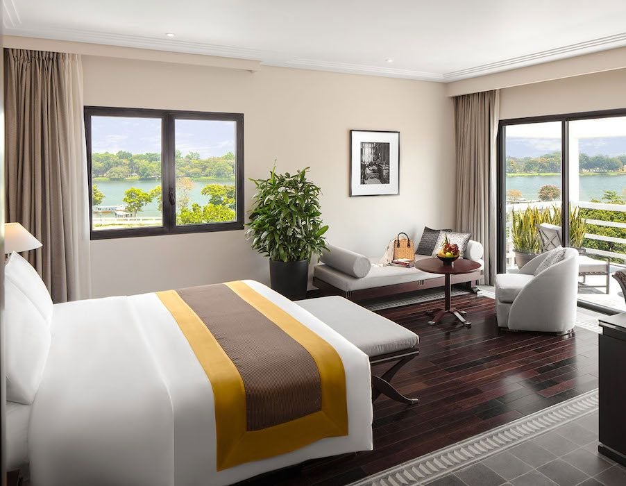 Elegant Deluxe River View room at Azerai La Residence, featuring colonial-style decor, spacious interior, and panoramic views of the Perfume River in Hue, Vietnam