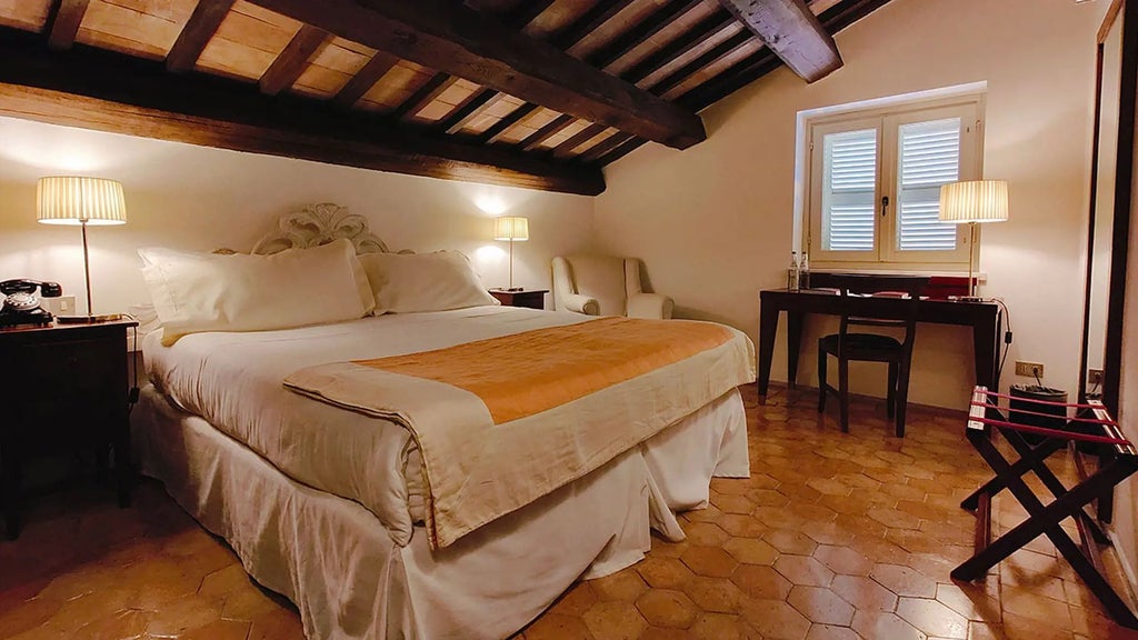 Elegant Renaissance-style hotel room with antique wooden furniture, soft cream linens, stone walls, and warm ambient lighting in a restored Italian palazzo