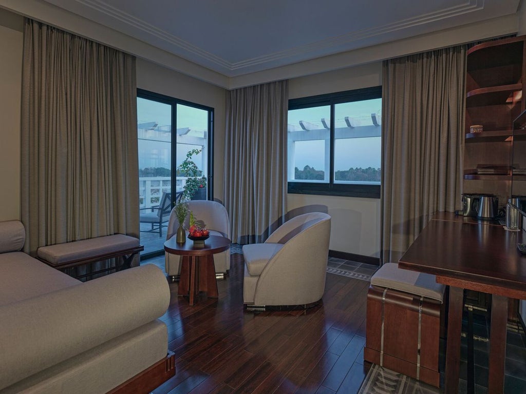 Elegant Perfume River Suite with river view, colonial-style furnishings, and plush king bed overlooking historic Hue's tranquil waterfront landscape