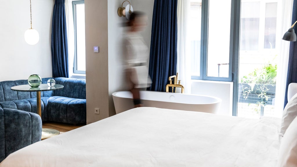 Luxurious corner suite at Gatsby Athens Hotel, featuring modern minimalist design with panoramic city views and elegant white and gray color palette