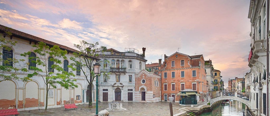 Elegant boutique hotel nestled in Italian countryside, featuring stone facade, manicured gardens, and panoramic Tuscan landscape with warm golden sunlight