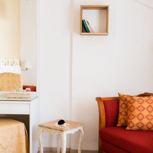 Elegant Italian villa room with plush white bedding, rustic wooden furniture, and soft natural light streaming through traditional shuttered windows.