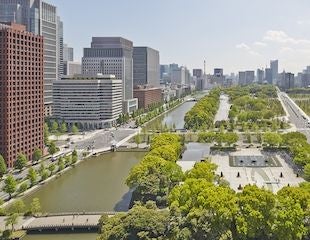 Luxurious hotel room in Tokyo with modern design, floor-to-ceiling windows overlooking Wadakura Fountain Park, featuring elegant twin/king bed and private balcony