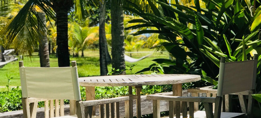 Luxurious wooden bungalow suite with elegant decor, large bed, and panoramic view of lush Brazilian coastal landscape at Fazenda São Francisco do Corumbau