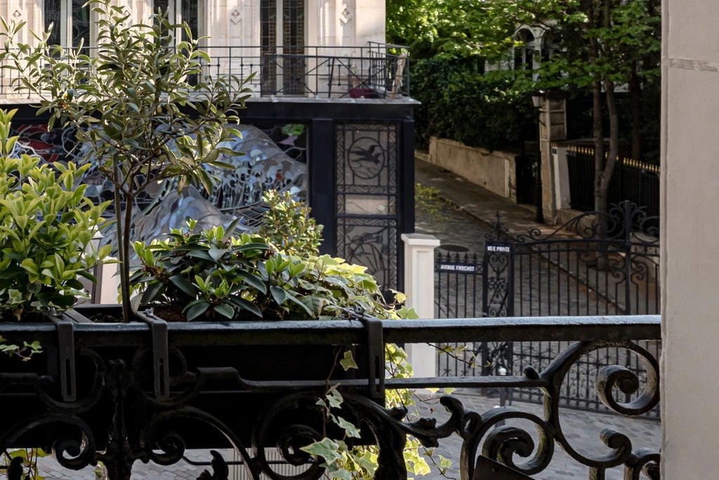 Elegant Parisian hotel room with plush navy blue bedding, vintage-inspired decor, warm wood furnishings, and soft ambient lighting in a chic boutique setting