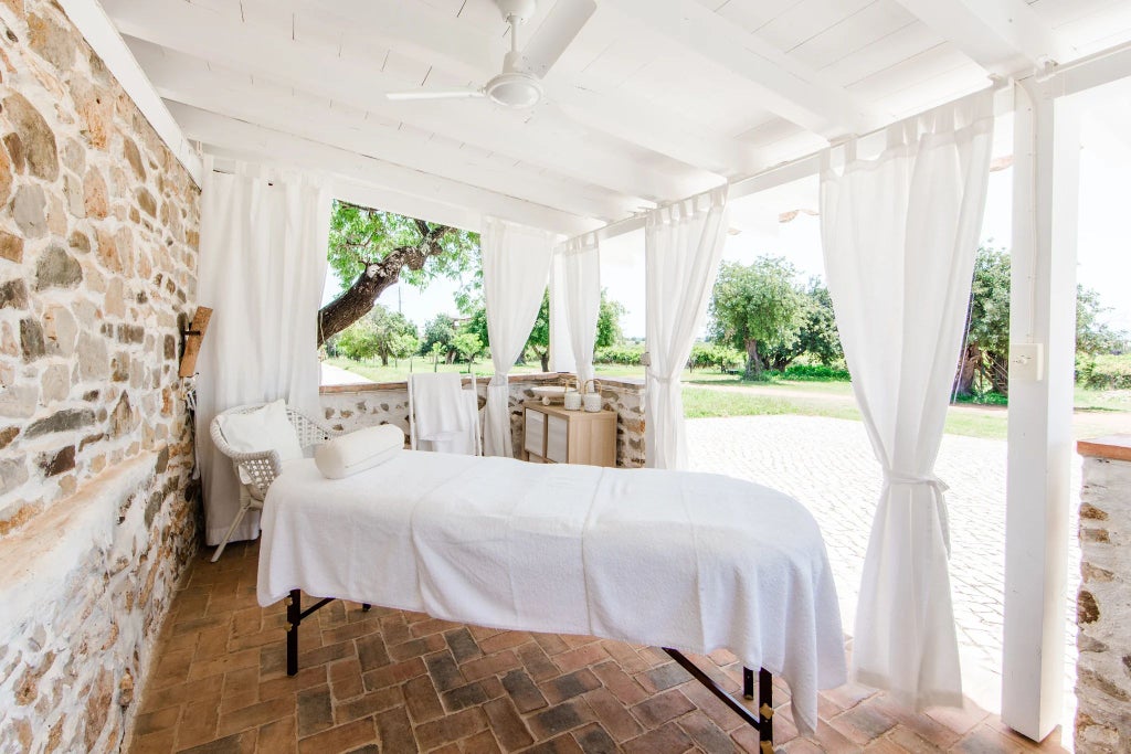 Rustic Portuguese farmhouse with wooden veranda, sun-drenched terracotta tiles, surrounded by verdant hills and traditional stonework at Hotel Conversas de Alpendre