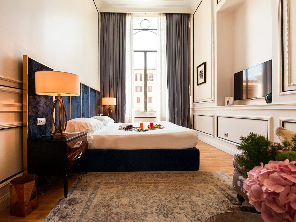 Elegant double deluxe hotel room with plush white linens, contemporary Italian design, soft neutral tones, and refined minimalist decor in Palazzo Dama