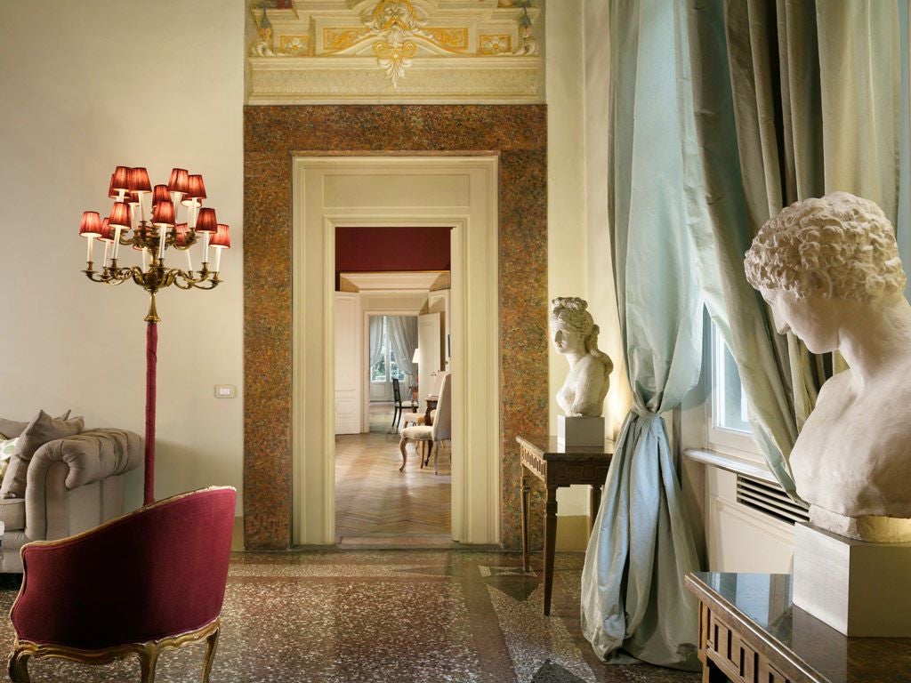 Historic 16th-century Palazzo di Camugliano in Florence, with elegant stone facade, arched windows, and lush Tuscan garden in soft afternoon light