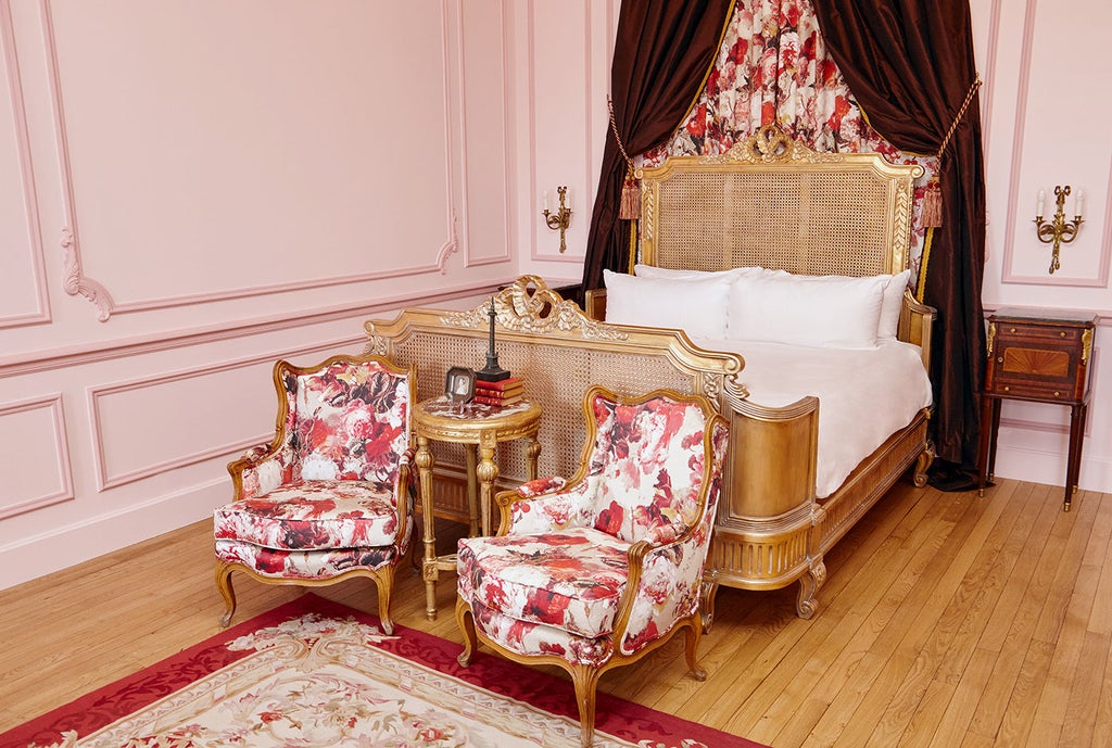 Opulent King Suite with panoramic French countryside views, featuring period furniture, crystal chandelier, and cream-colored decor