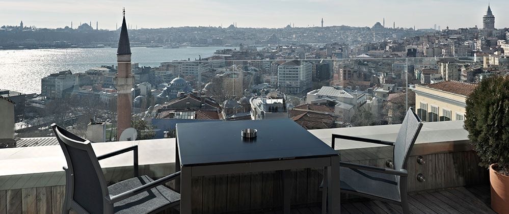 Luxurious penthouse suite at scenset Hotel with panoramic city views, modern minimalist design, and floor-to-ceiling windows overlooking Istanbul's vibrant skyline